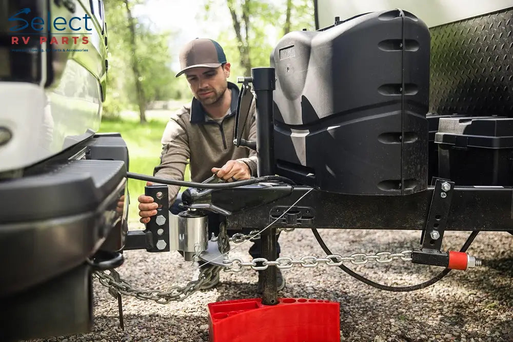 Man attaching a hitch to a trailer with a focus on safety and preparation.